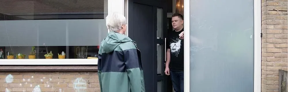 Ambulante GGZ verpleegkundige aan de voordeur bij een cliënt