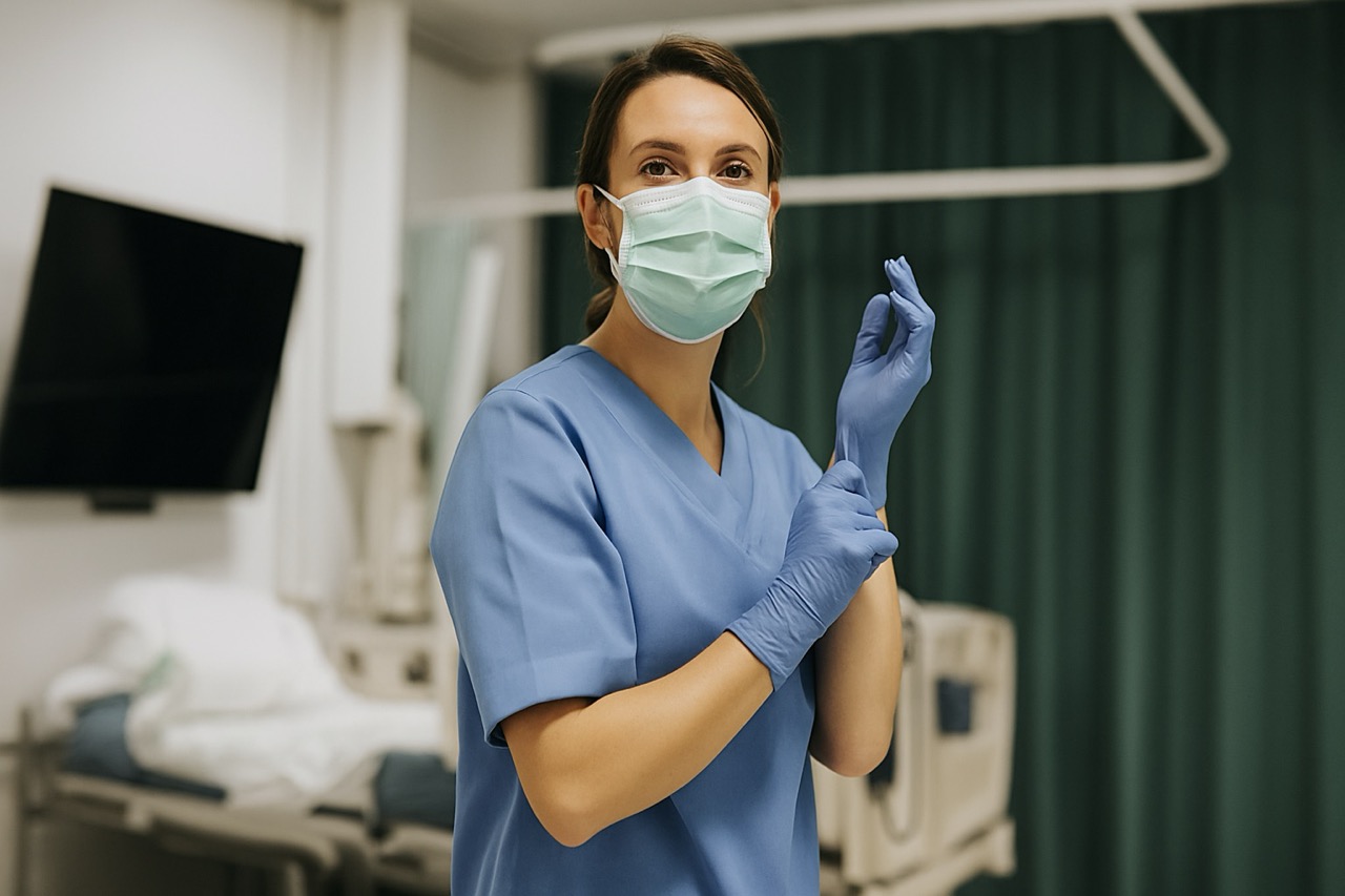 Verpleegkundige in het ziekenhuis met een mondkapje en handschoenen aan